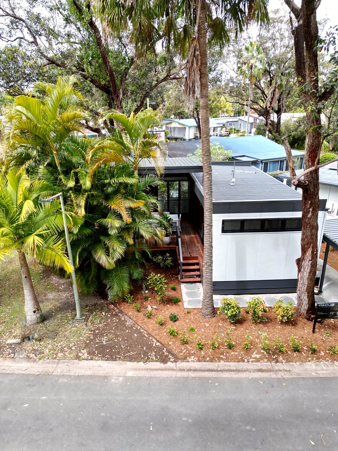 Drone view of a Coastline Studios home among the palms on the Coffs Coast